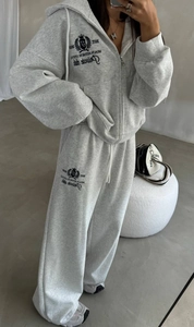 Détail du survêtement gris à capuche montrant la broderie Sport Club et la texture du coton