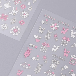 Detail of Christmas nail art stickers featuring pink and white snowflakes and reindeer designs