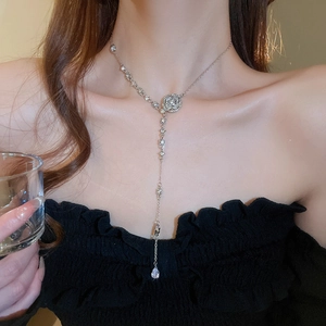 Detail of flower tassel necklace featuring brilliant diamonds and water drop pendant on model