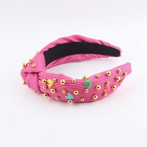 Detail of pink striped knotted headband with colorful enamel hearts and gold beads