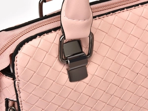 Close-up of pink woven leather texture with high-quality gunmetal hardware and zippers