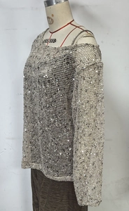 Makro-Detail des locker gestrickten Pailletten-Tops mit silbernem Schimmer-Muster