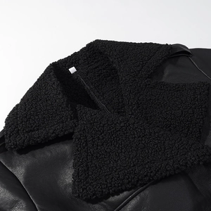 Close-up of black faux leather jacket collar with thick faux fur trim and textured finish