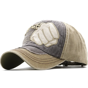 Detail of vintage washed baseball cap with embroidered fist logo and distressed brim