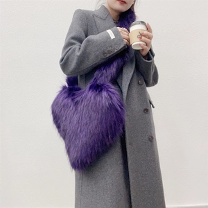 Detail of purple faux fur heart-shaped crossbody bag worn with a gray coat