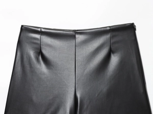 Gros plan sur la texture litchi et les coutures du short taille haute en similicuir