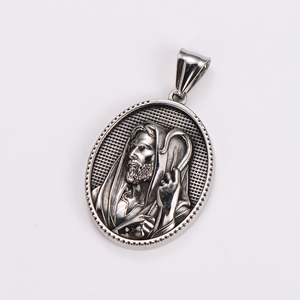 Macro shot of silver metal oval pendant with religious Jesus relief and vintage finish