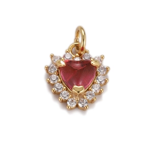 Macro detail of heart pendant with red gemstone and cubic zirconia in gold setting