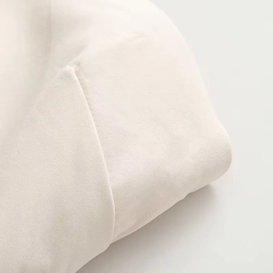 Detailed macro view of cream white textured fabric on a slim fit dress shoulder