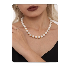 Detail shot of 12mm white pearls necklace with small gold spacers on a model