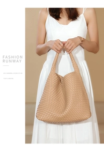 Close-up of beige woven tote bag with a wide shoulder strap and premium leather texture