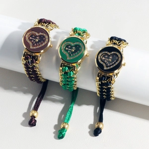 Three ladies' quartz watches with heart dials and woven straps on white display stands