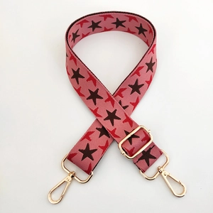 Close-up of pink star pattern strap with gold metal lobster clasps and slider buckle