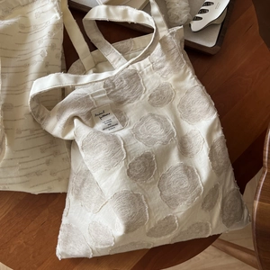 Minimalist beige cotton linen tote bag with brown polka dot jacquard on a wooden table