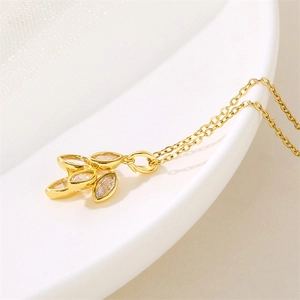 Collier feuille dorée pour femme avec pierres en zircon blanc sur fond blanc épuré