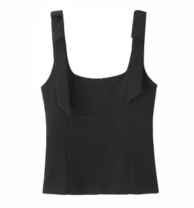 Detail of black sleeveless top with wide shoulder straps featuring a bow tie design