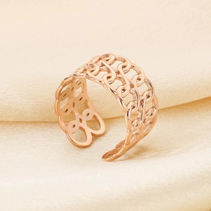 Macro detail of rose gold hollow chain ring on beige silk background showing metal texture