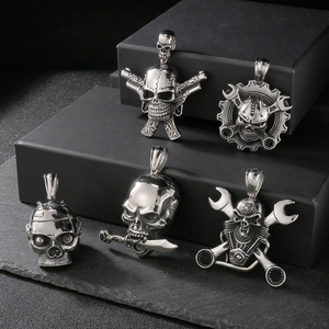 Detail of five punk gothic skull pendants including double guns and wrench mechanical designs