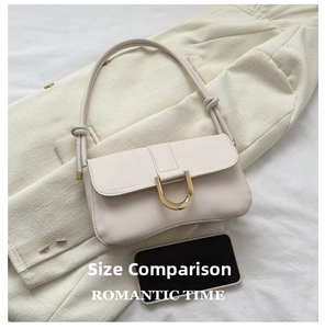 Detailed size comparison of the cream shoulder bag next to a smartphone for scale