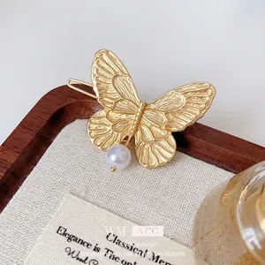 Elegant gold butterfly hair clip with faux pearl charm for women in French retro style