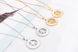 Close-up of stainless steel necklaces with white shell and boy girl silhouette pendants