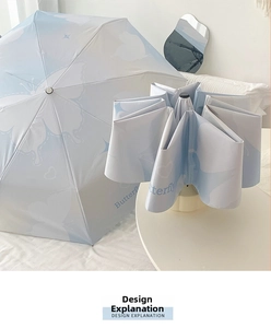 Detail of light blue folding umbrella with elegant butterfly print and gradient design