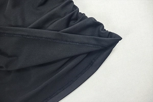 Gros plan des coutures haute densité et de la texture du tissu élastique d'une robe noire