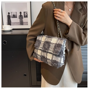 Detail of grey and white tweed chain bag with fringe and woven leather strap detail