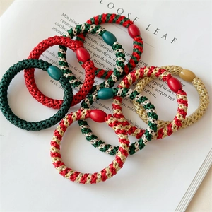 Detail of red and green braided Christmas hair ties with colorful decorative beads