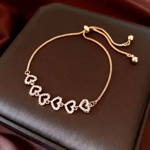 Gold-plated heart bracelet with zircon flowers on a luxury jewelry gift box
