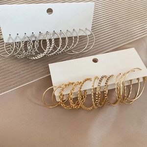 Détails de sets de créoles argentées et dorées avec textures torsadées et strass