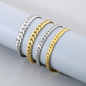 Flat Cuban link chain bracelet set in gold and silver finish on display stand