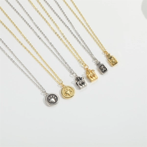 Close-up of elegant gold and silver bear pendants with dog paw patterns on necklaces