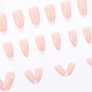 Pink almond press-on nails with white French tips and small heart patterns on white background
