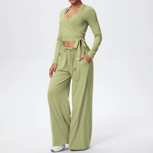 Détail d'un ensemble de yoga vert olive avec haut court noué et pantalon large à cordon