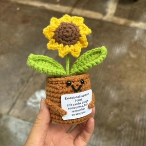 Close-up of handmade crochet sunflower plant with an emotional support message card