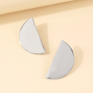 Detailed view of semi-circular silver metal earrings with a polished mirror finish surface