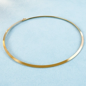 Detail of a 4mm gold polished titanium steel choker necklace on a soft blue background