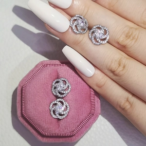 Detail of silver flower stud earrings with zircon stones in a pink velvet jewelry box