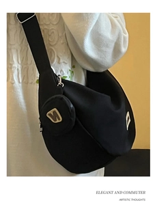 Dettaglio borsa a mezzaluna in nylon nero con tracolla larga e piccolo portamonete rotondo