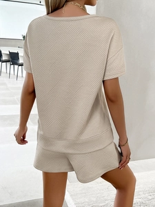 Rear view of beige two-piece lounge set with textured knit top and shorts for women