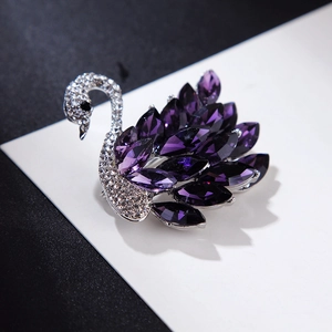Detailansicht der Schwanenbrosche mit violetten Kristallen und funkelnden Strasssteinen