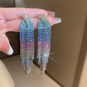 Close-up of gradient rhinestone tassel earrings with shimmering star-shaped glints