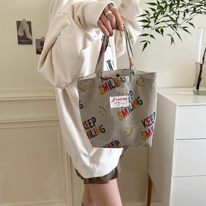 Detail of corduroy tote bag with Keep Smiling print and magnetic clasp closure