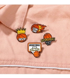 Macro detail of four creative enamel basketball lapel pins on textured fabric