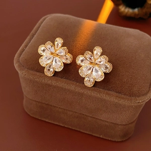 Macro shot of sparkling zircon flower earrings set on a premium brown velvet jewelry box