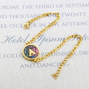 Golden Figaro chain bracelet with round abalone shell pendant featuring letter A