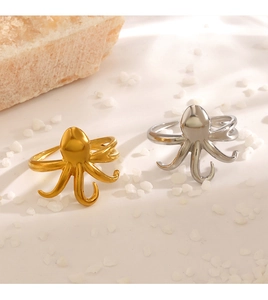Detailed view of octopus shaped open rings in gold and silver finishes on rock