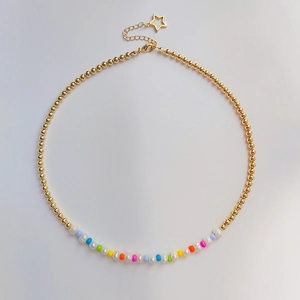 Detail of beaded gold chain with colorful beads, pearls, and star pendant