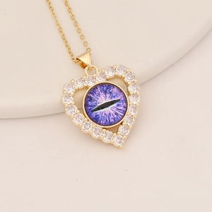Detail of gold heart pendant with purple dragon eye stone and sparkling zirconia inlay